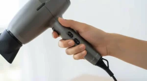Close-up of the comfortable grip on a mid-range hair dryer. Gros plan sur la poignée ergonomique d'un séchoir à cheveux de milieu de gamme.