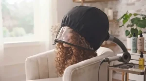 Using the hooded dryer attachment to set curls gently and effectively.