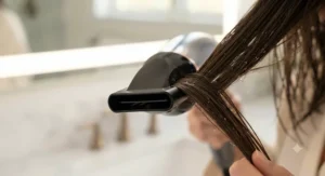 Close-up of the specialized concentrator nozzle on a root-lifting hair dryer directing airflow to the roots.